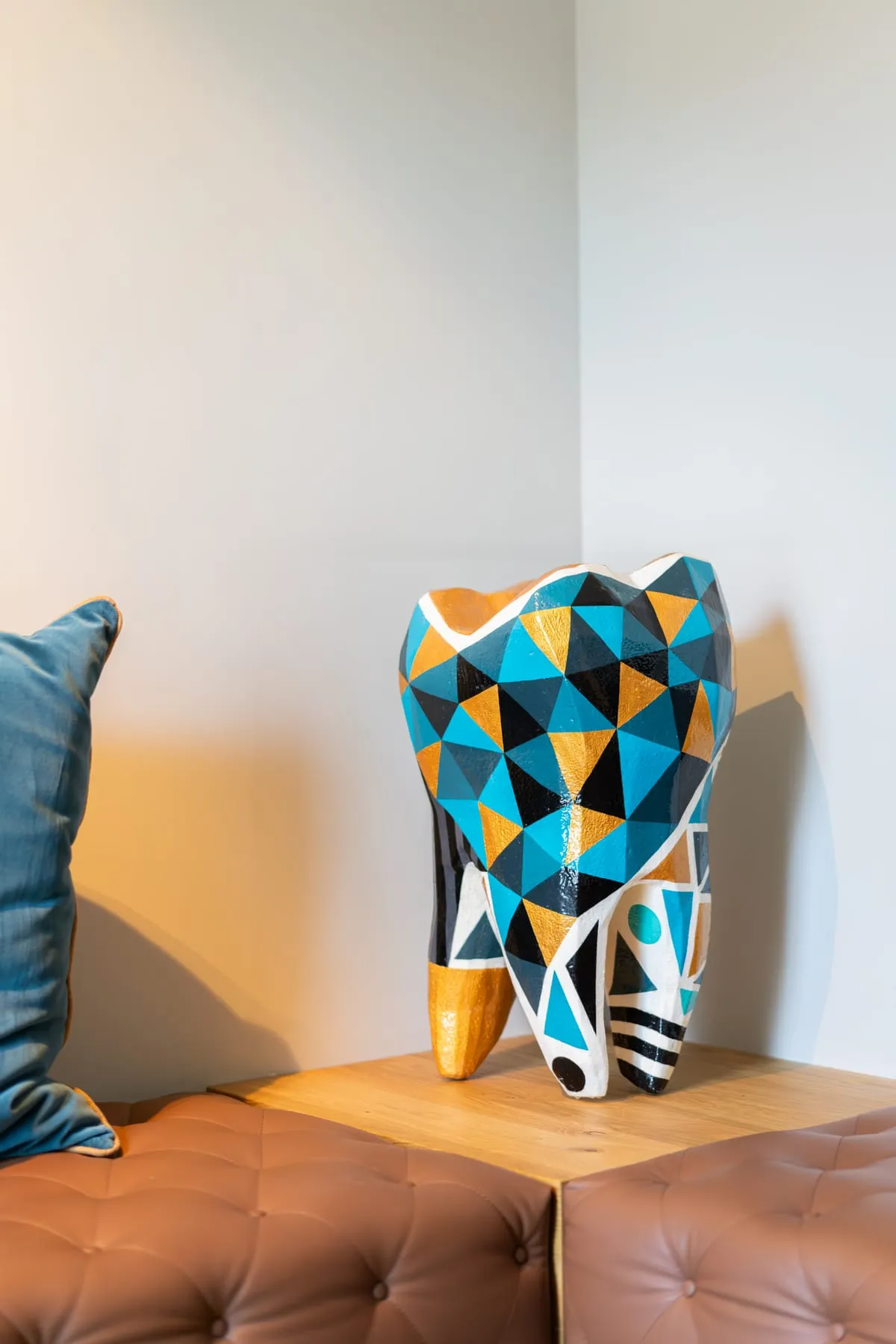 Waiting area with leather bench and painted tooth sculpture